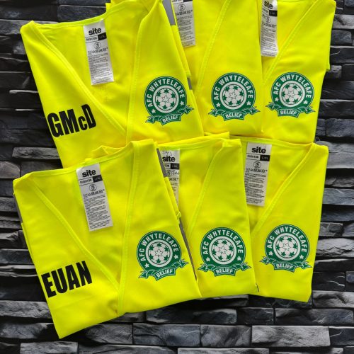 Bright yellow high-visibility vests laid flat, each printed with the AFC Whyteleafe football crest and personalised names in bold lettering.