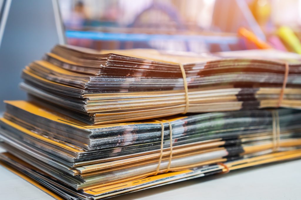 Stack of printed and photocopied leaflets bundled together on a desk