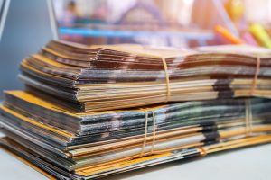 Stack of printed and photocopied leaflets bundled together on a desk