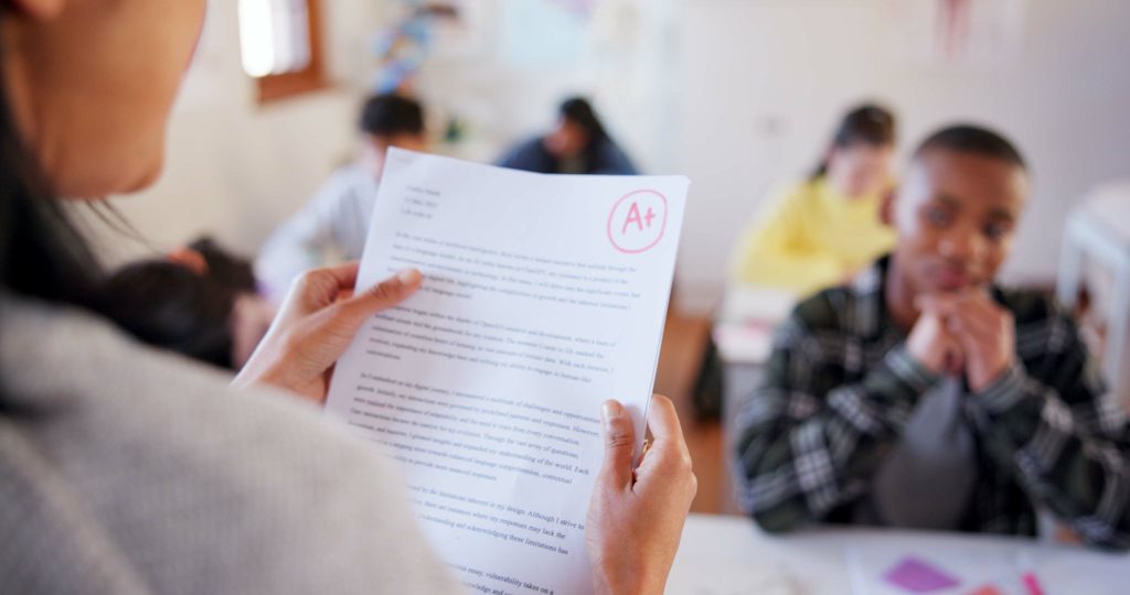 Student holding a marked essay with an A+ grade, highlighting professional essay printing for students.